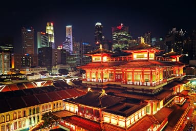 night view on Singapore old chinese building in lights and skyscrapers background