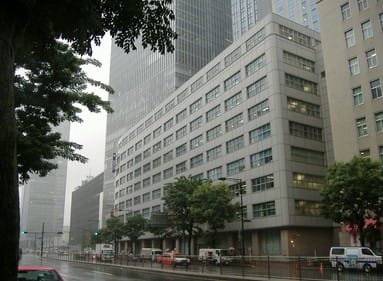 an eight-story building next to a skyscraper in tokyo, japan