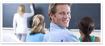 male student is smiling while female students are studying in a TEFL class